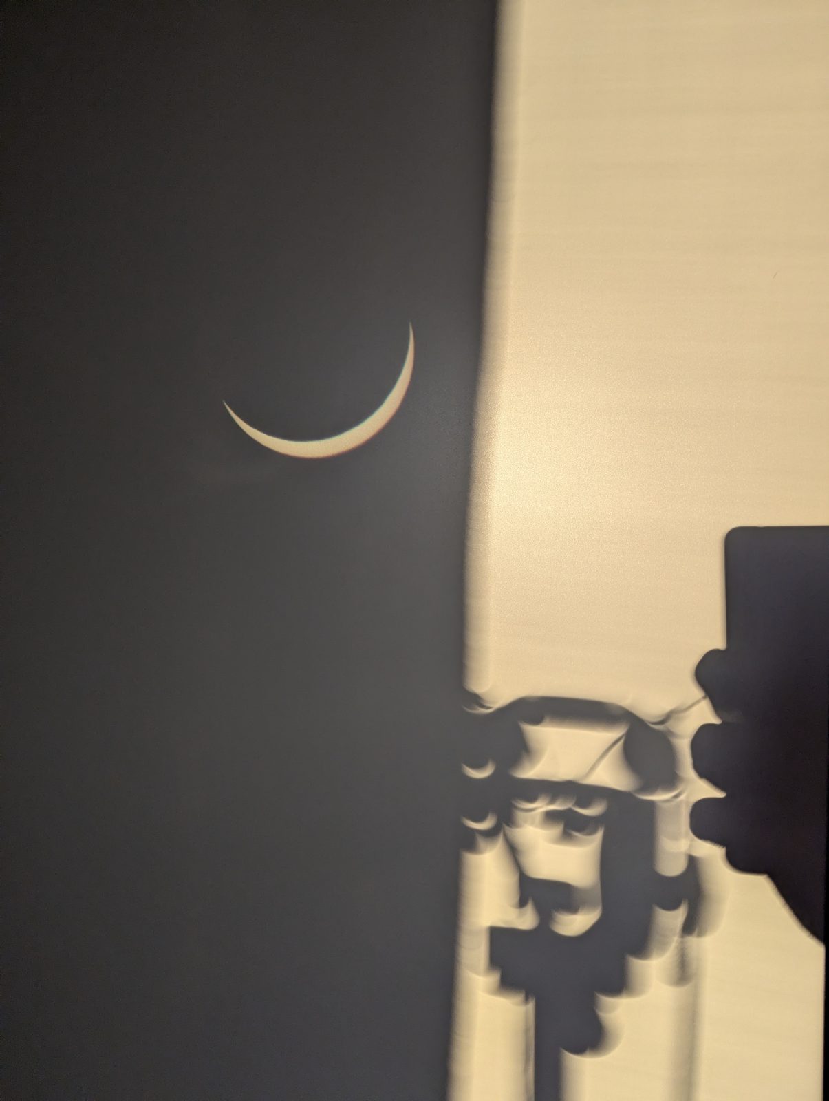 Crescent eclipse projected onto a wall through a pinhole