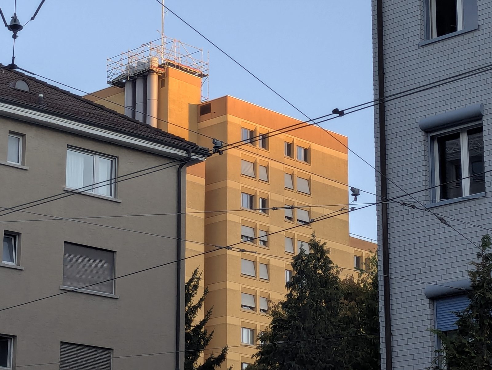 Apartment buildings and tram wires glowing at sunset